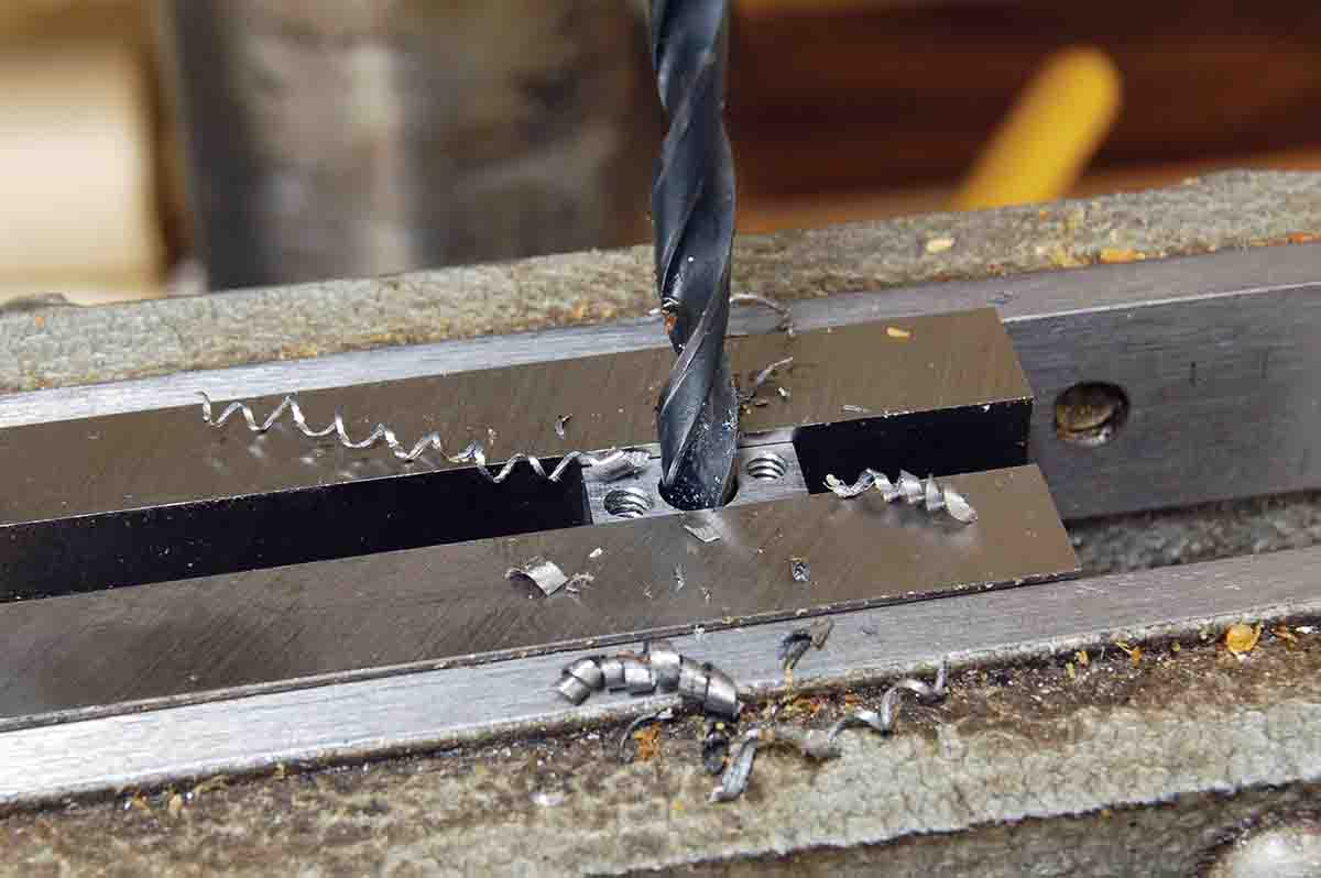 A relief hole is drilled in the elevation slide, followed by a 1⁄16-inch hole to form an aperture.